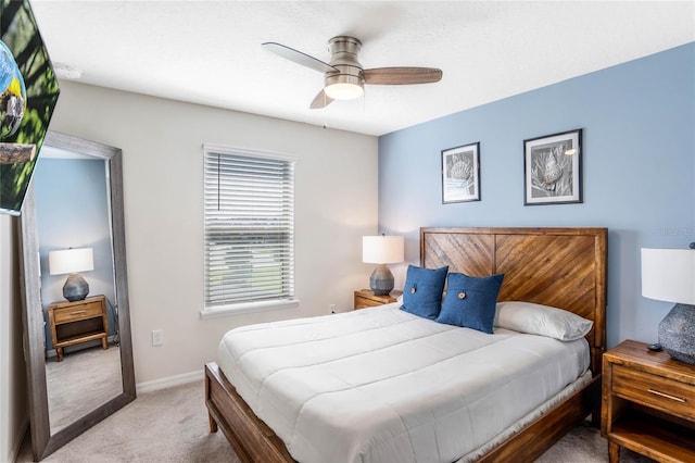 bedroom featuring baseboards, ceiling fan, and light colored carpet