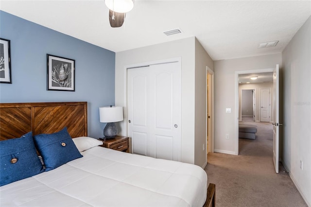 carpeted bedroom featuring ceiling fan, a closet, visible vents, and baseboards