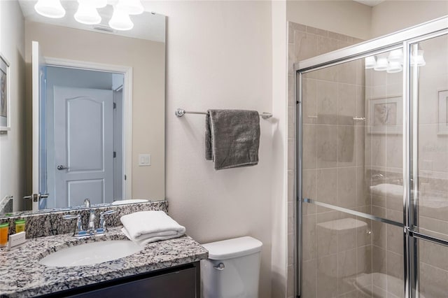 full bathroom featuring toilet, a stall shower, and vanity