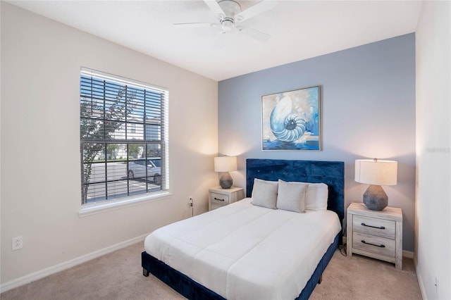 bedroom featuring light carpet, ceiling fan, and baseboards