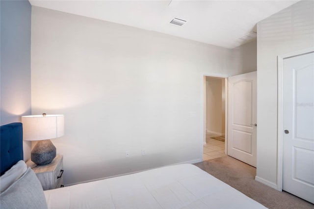 bedroom featuring light carpet, visible vents, and baseboards