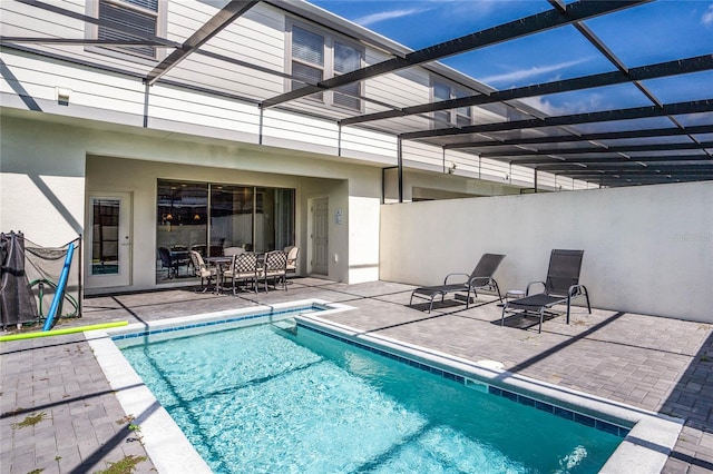 pool with glass enclosure and a patio area