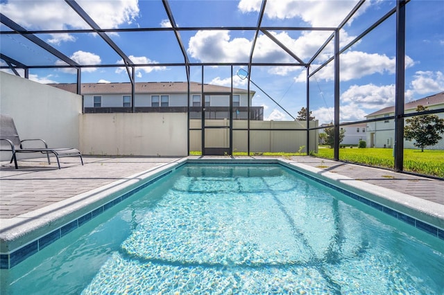 pool featuring glass enclosure and a patio area