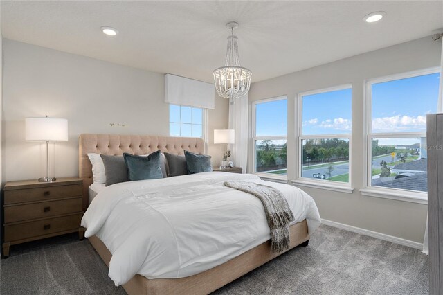 carpeted bedroom featuring an inviting chandelier and multiple windows