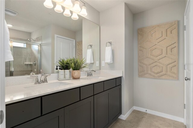 bathroom with tile patterned floors, a shower with door, and vanity