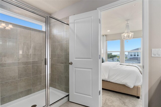 bathroom with an enclosed shower and a chandelier