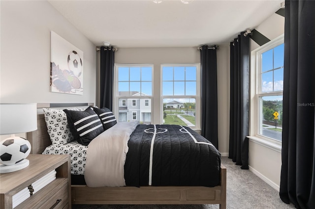 bedroom with multiple windows and light carpet