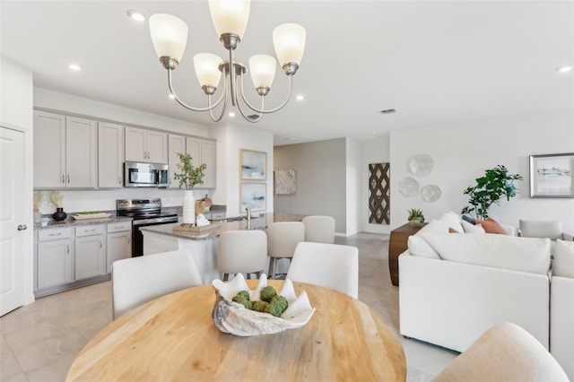 tiled dining room with a chandelier