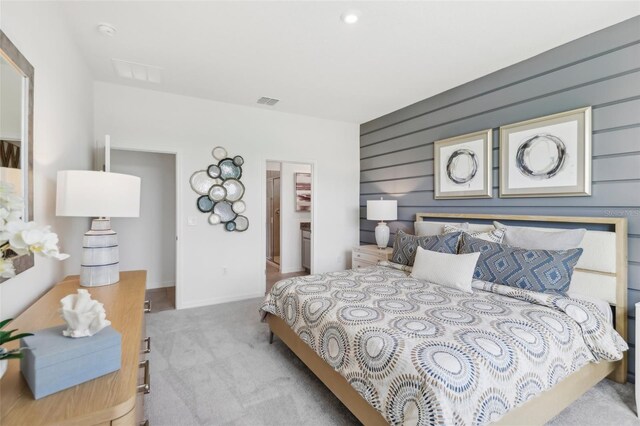 bedroom featuring a walk in closet and light carpet