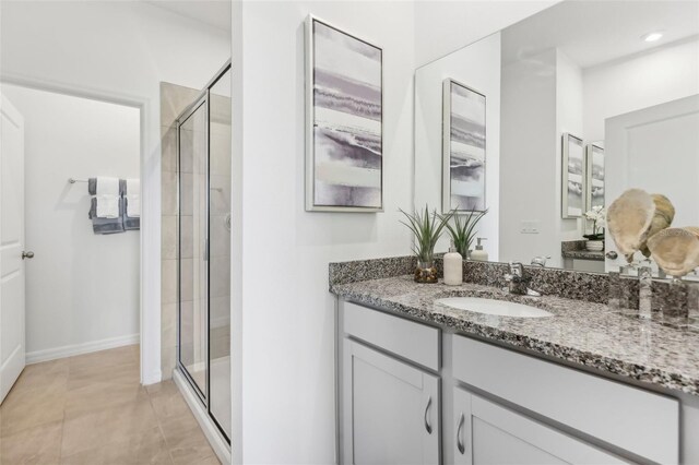 bathroom featuring tile patterned floors, an enclosed shower, and vanity