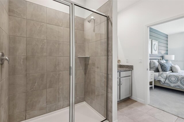 bathroom featuring a shower with shower door, vanity, and tile patterned floors