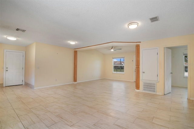 unfurnished room with a textured ceiling, ceiling fan, and light tile patterned floors