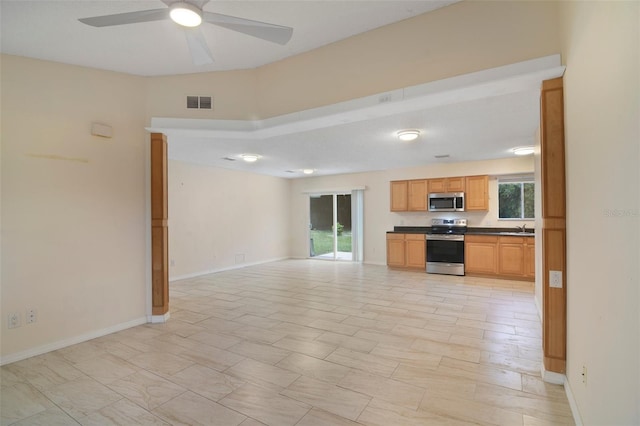 unfurnished living room featuring ceiling fan, sink, and light tile patterned floors