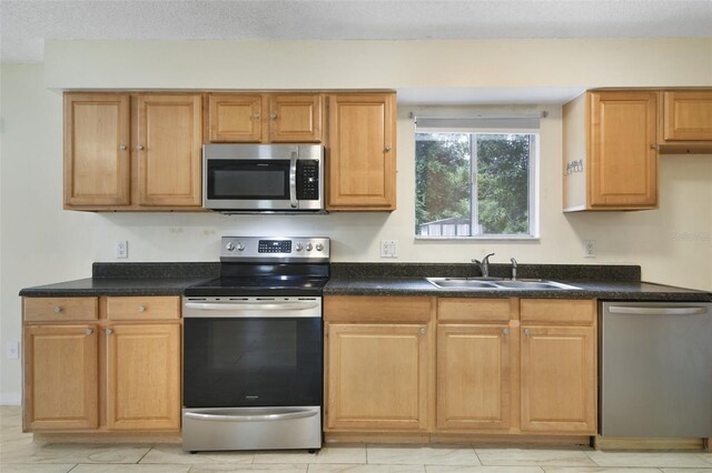 kitchen featuring light tile patterned flooring, appliances with stainless steel finishes, and sink