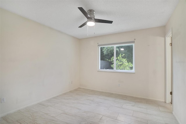 tiled empty room featuring ceiling fan and a textured ceiling