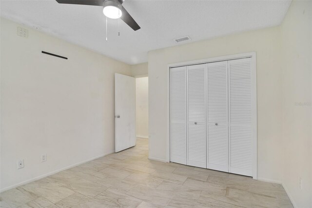 unfurnished bedroom featuring ceiling fan, a closet, and light tile patterned floors