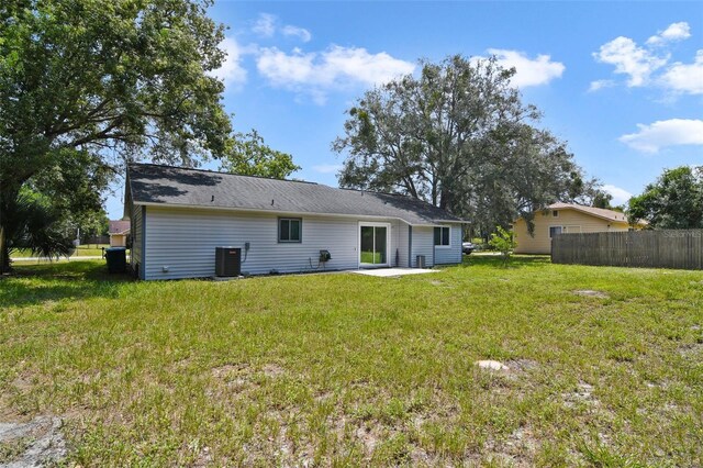 back of house with a patio area, a yard, and central AC