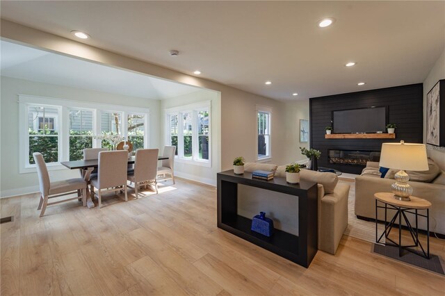 living area with light wood-style flooring, recessed lighting, a fireplace, visible vents, and baseboards