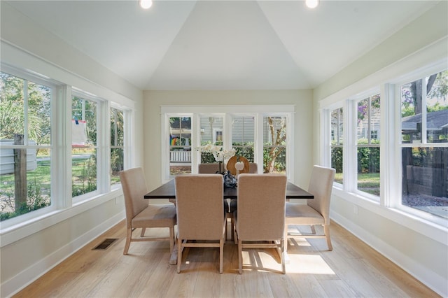 sunroom / solarium featuring vaulted ceiling, plenty of natural light, and visible vents