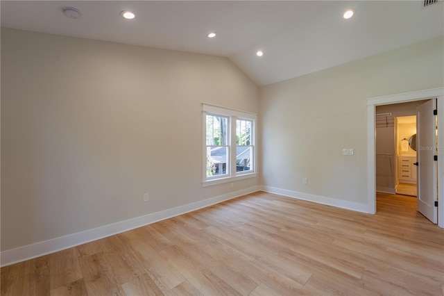 empty room featuring lofted ceiling, recessed lighting, light wood-style flooring, and baseboards