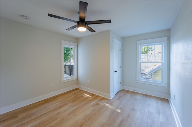 spare room with a ceiling fan, light wood-style flooring, and baseboards