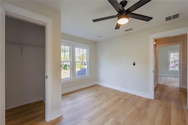 unfurnished bedroom with visible vents, baseboards, a ceiling fan, light wood-style flooring, and a closet