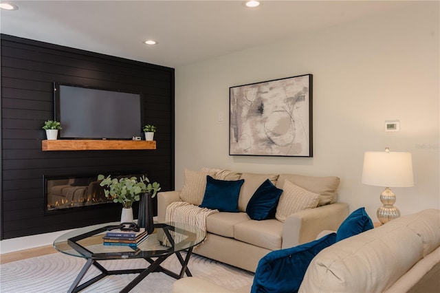 living area featuring a glass covered fireplace, light wood-style flooring, and recessed lighting