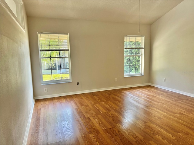 empty room with baseboards and light wood finished floors