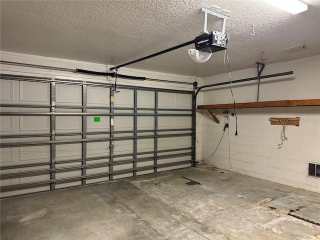 garage with a garage door opener and concrete block wall