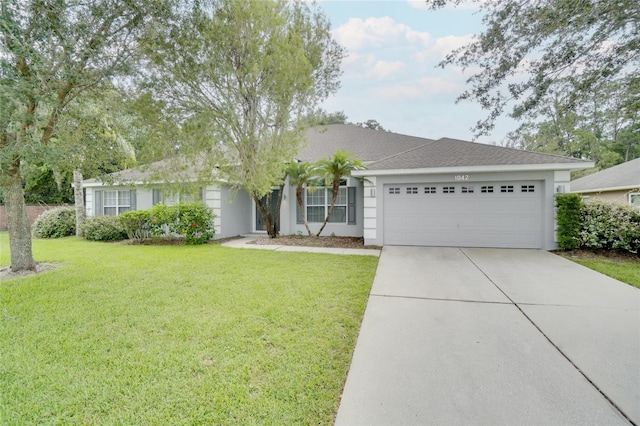 ranch-style home with a garage and a front lawn