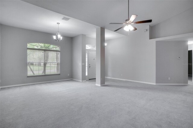 unfurnished living room with ceiling fan with notable chandelier, high vaulted ceiling, and light carpet