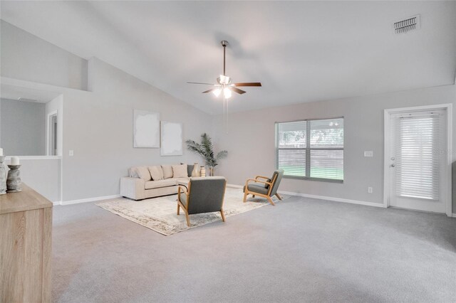 carpeted living room with ceiling fan and high vaulted ceiling