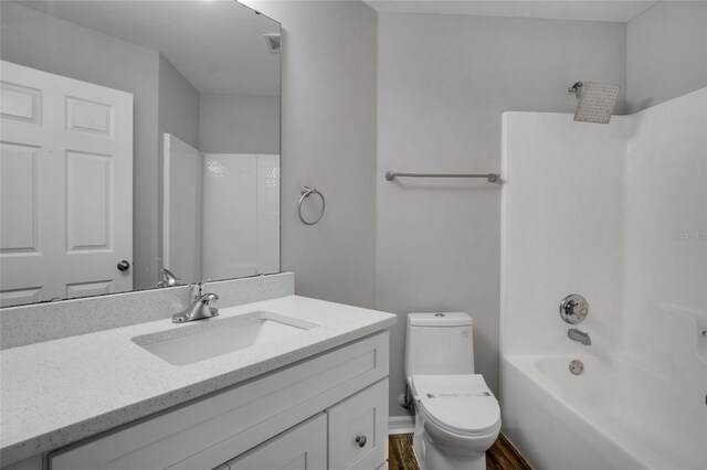 full bathroom with bathtub / shower combination, vanity, hardwood / wood-style floors, and toilet