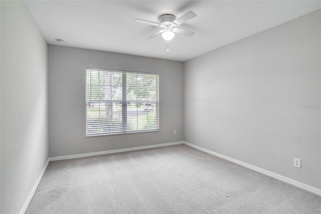 carpeted spare room with ceiling fan