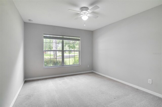 carpeted spare room with ceiling fan