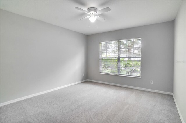 spare room featuring ceiling fan and light carpet