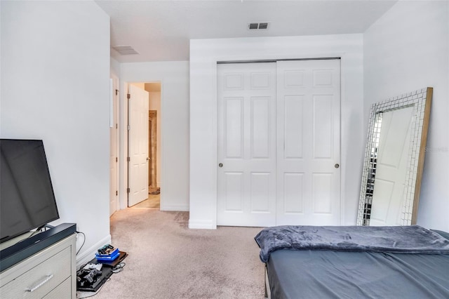 bedroom featuring light colored carpet and a closet