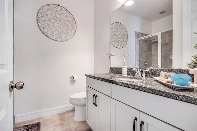 bathroom featuring tile patterned flooring, vanity, a shower with shower door, and toilet