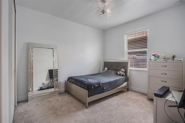 bedroom featuring light carpet and a notable chandelier