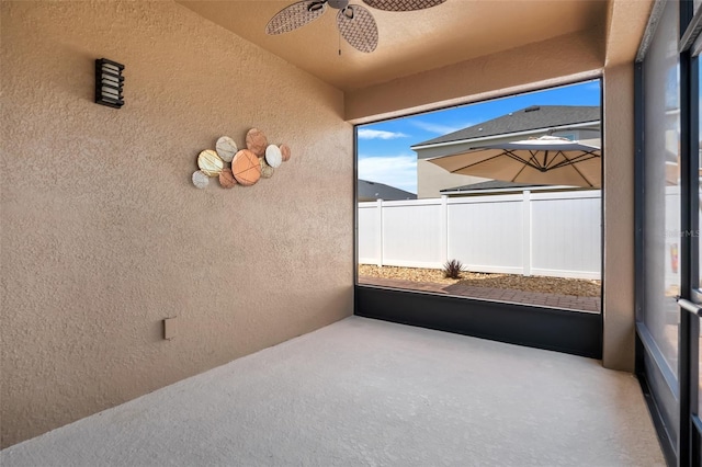 unfurnished sunroom featuring ceiling fan