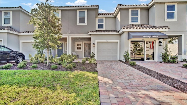 view of front of property featuring decorative driveway, a tile roof, stucco siding, a front yard, and a garage