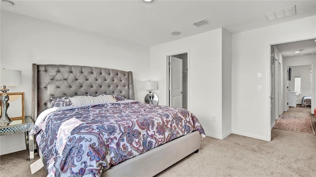 bedroom featuring baseboards, visible vents, and light colored carpet