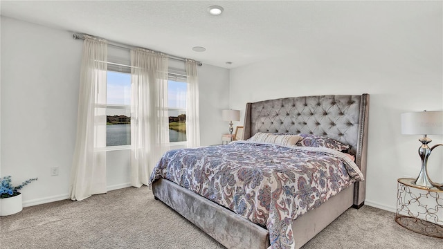 bedroom with carpet, baseboards, and a textured ceiling