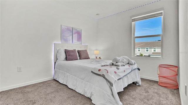 bedroom featuring light colored carpet and baseboards