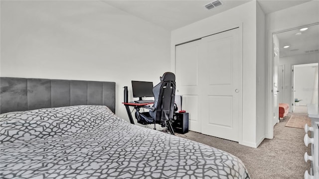 bedroom with a closet, visible vents, and carpet flooring