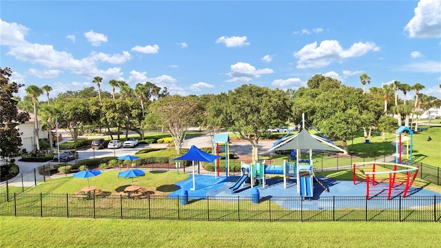 community jungle gym featuring fence and a lawn