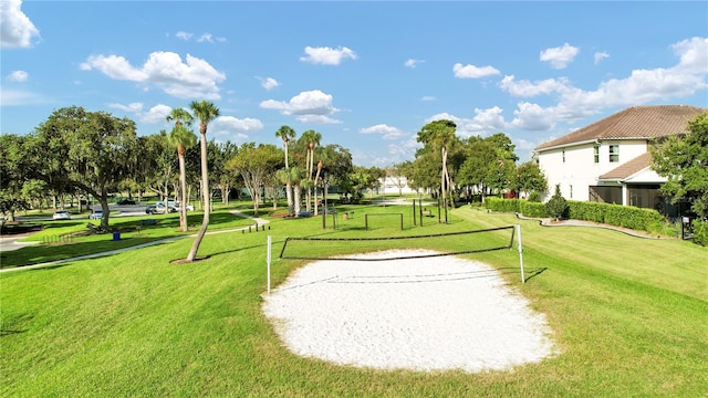 surrounding community with a lawn and volleyball court