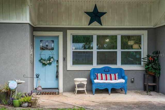 entrance to property with ceiling fan and a patio