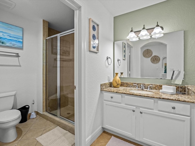 bathroom featuring tile patterned flooring, vanity, an enclosed shower, and toilet