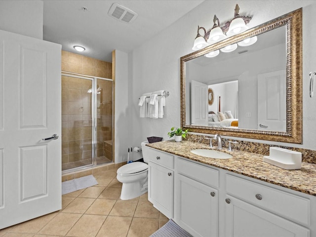 bathroom featuring tile patterned floors, vanity, an enclosed shower, and toilet